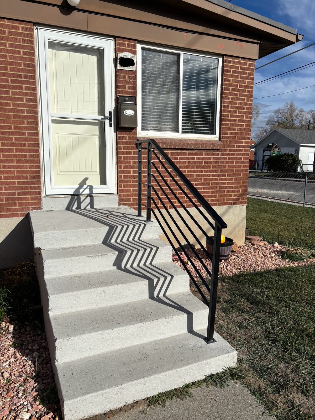 Black steel handrail on brick home stoop